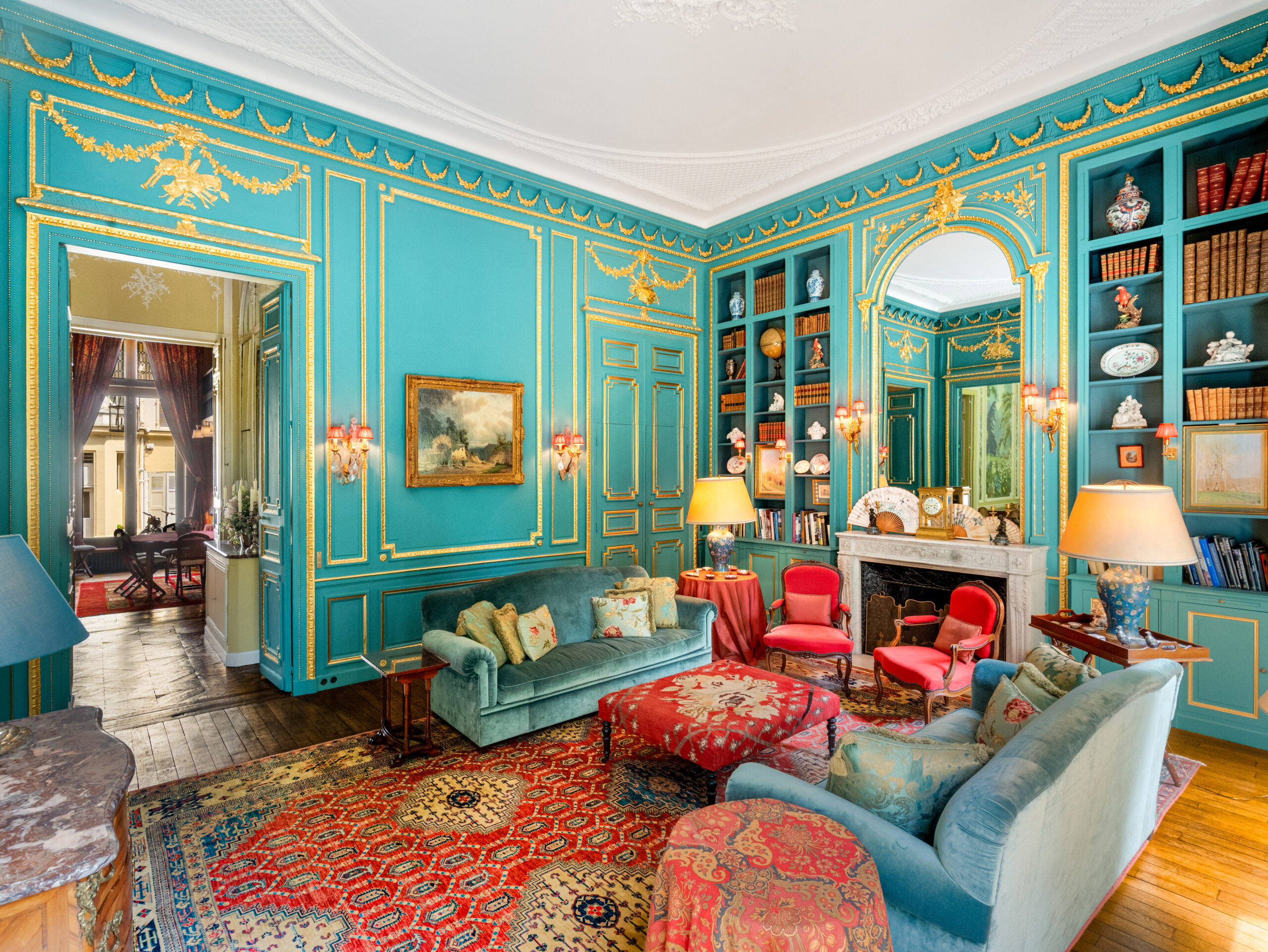 Salon historique de l’Hôtel de Montgascon à Paris, aux boiseries turquoise et dorées, bibliothèque, tapis anciens, cheminée en marbre et mobilier élégant Idéal pour accueillir vos réceptions parisiennes